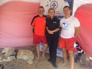 ratownicy z policjantką, pies - ratownik i ćwiczenia na plaży